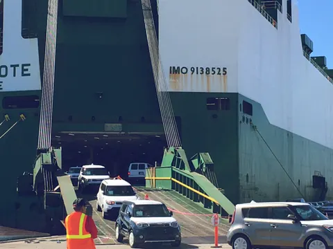 Cars driving up the ramp into a Ro-Ro ship