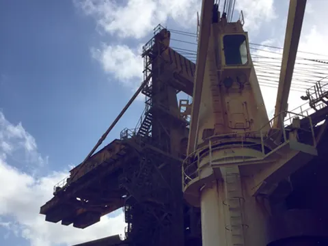 A ship's deck crane and a loading gantry against the sky