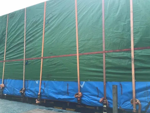 Cargo under a green tarpaulin, held down with orange straps