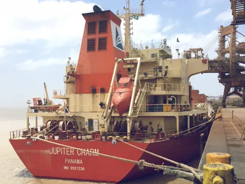 A red and cream cargo ship moored alongside a quay